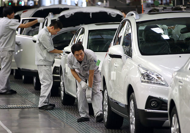 Рабочие проводят окончательную проверку автомобилей на конвейере завода Dongfeng Peugeot-Citroen Automobile в городе Ухан, Китай