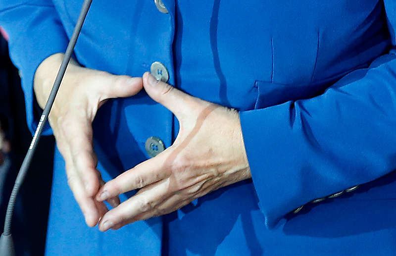 Руки канцлера, сложенные в традиционный для нее ромб. Этот ромб - гармонизация противонаправленных сил в стабильную конструкцию