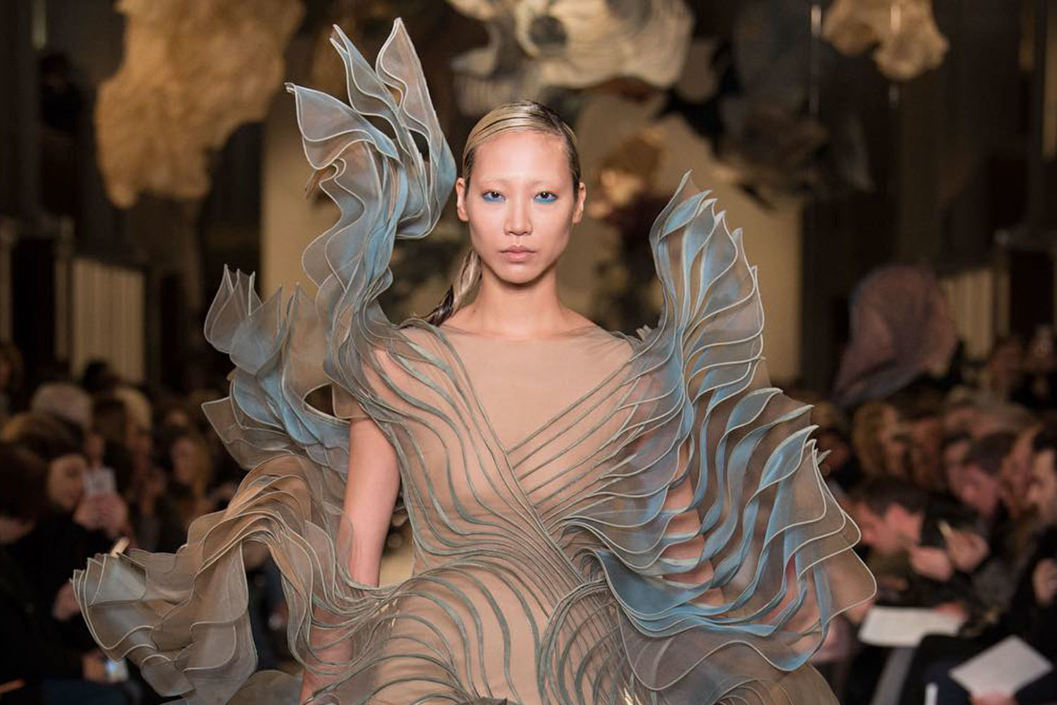 Модель на показе Iris van Herpen в платье из многослойных изогнутых лепестков
