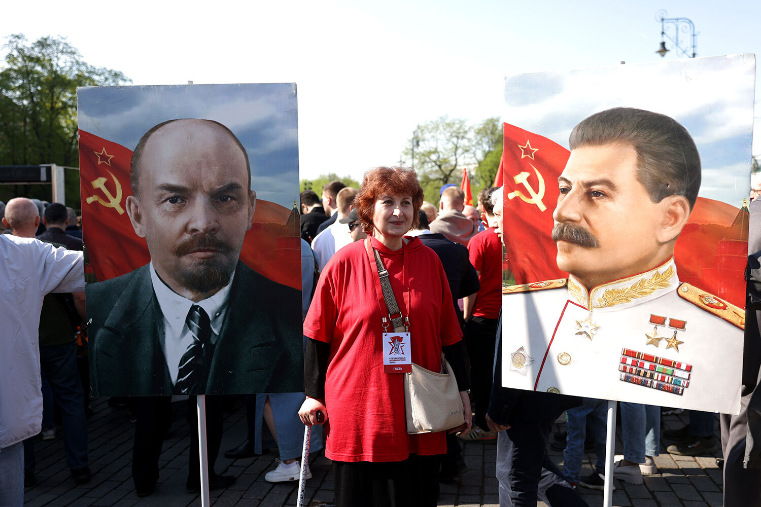 Участница акции с портретами Ленина и Сталина.