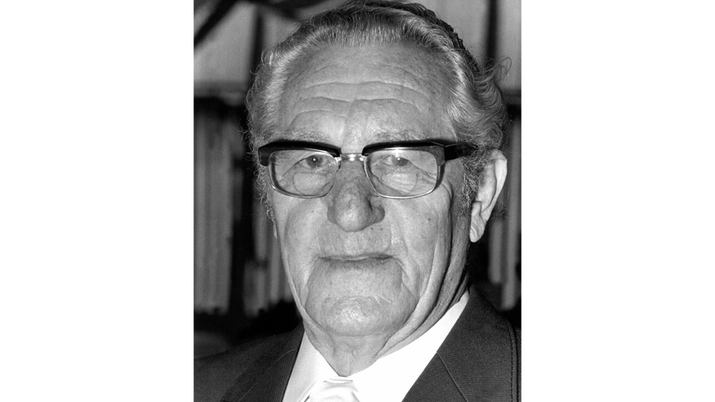 Адольф Дасслер, основатель компании Adidas, держит кроссовки, выставленные в магазине в Германии в 1973 г.