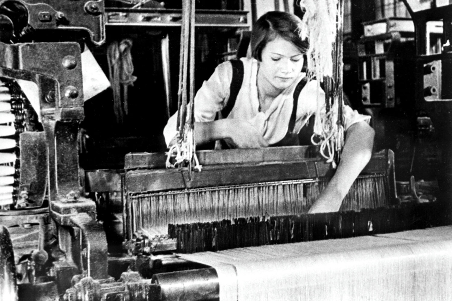 Ивановская ткачиха Евдокия Виноградова работала на фабрике им. Ногина в Вичуге. Сначала она обслуживала 16 автоматических станков, а позже перешла на типовой норматив в 26 агрегатов. В начале 1935 г. на предприятии появились экспериментальные участки из 40 и 52 станков, один из которых доверили Виноградовой. Однако и этого руководству показалось мало, поскольку на американских фабриках в то время ткач мог обслуживать сразу по 80 автоматов.Весной был создан комплект из 70 станков, что являлось абсолютным рекордом СССР. Обслуживание автоматов поручили Евдокии Виноградовой, а ее сменщицей стала Мария Виноградова. Информация о ткачиках-рекордсменках появилась в прессе в сентябре 1935 г., породив так называемое виноградовское движение. 1 октября Виноградовы перешли на 100 станков, установили мировой рекорд производительности труда, за что были удостоены ордена Ленина. Вскоре их обошли ткачихи с фабрики «Красный Профинтерн», где был укомплектован участок из 140 станков, однако тандем быстро вернул себе лидерский статус, перейдя на 150 автоматов. В 1938 г. Виноградовы установили новый мировой рекорд, обслуживая сразу 284 станка.Хотя трудовые подвиги Евдокия и Мария Виноградовы устанавливали вместе, основное внимание уделялось первой, поскольку она обладала яркой внешностью и обаянием. В советской прессе «стахановку» называли символом «нового человека», а в зарубежной – «мисс СССР». Вместе с другими передовицами ткачиха стала прототипом для образа Тани Морозовой в фильме «Светлый путь» (1940), который исполнила Любовь Орлова. В честь Виноградовых названа улица в Вичуге, а также установлена мозаичная стела «Идущие впереди».