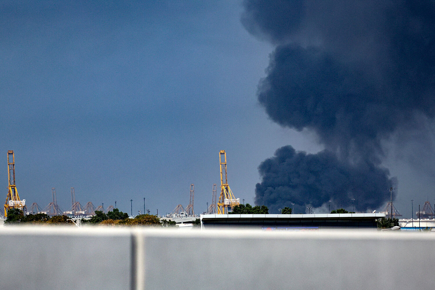 В ответ Иран атакует американские военные базы и нефтяную инфраструктуру по всему Ближнему Востоку. Помимо Израиля под удары попали объекты в Объединенных Арабских Эмиратах, Катаре, Кувейте, Бахрейне, Саудовской Аравии, Иордании и Ираке. Более 150 баллистических ракет и свыше 500 иранских беспилотников были перехвачены в небе над ОАЭ, сообщили в минобороны страны. Отдельные БПЛА долетают до целей: очевидцы фиксировали взрывы в Дубае в районе порта Джабаль-Али и около отеля «Бурдж-аль-Араб».На фото: дым поднимается над портом Джабаль-Али, ОАЭ.