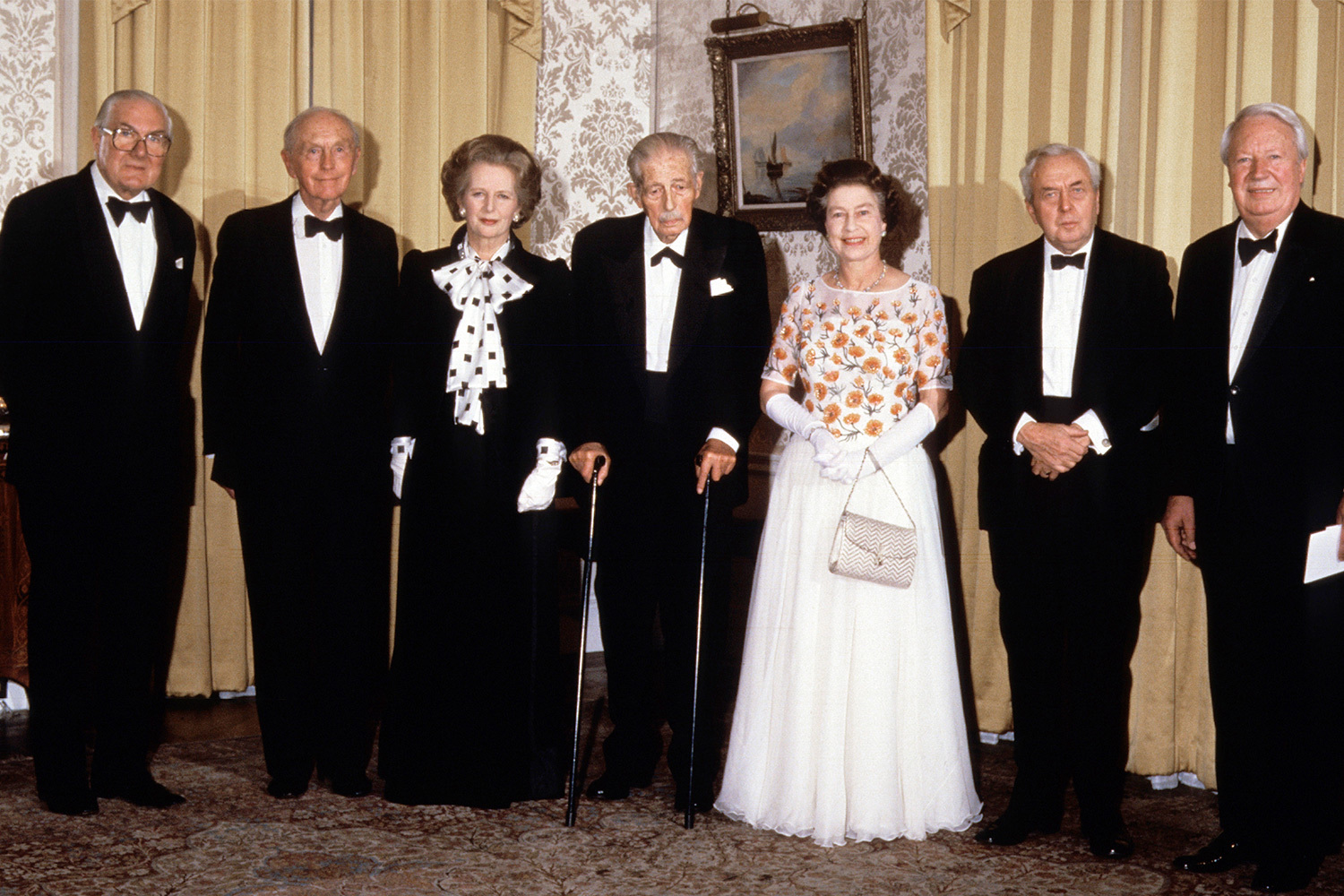 Великобритания – конституционная монархия: королева официально назначает глав правительств, может распустить парламент и наложить вето на принятые им законы (последний раз этим правом на острове пользовались в 1708-м). При этом монаршие акты недействительны, пока не подписаны премьер-министром. В общей сложности за годы правления Елизаветы II сменилось 15 премьеров, начиная Уинстоном Черчиллем и кончая Лиз Трасс. Королева раз в неделю встречалась с действующим главой правительства, чтобы обсудить положение дел. Беседы были конфиденциальны, но фантазии про них стали основой для популярной пьесы Питера Моргана «Аудиенция».&nbsp;На фото: Елизавета II вместе с шестью бывшими премьер-министрами Великобритании: Джеймсом Каллаганом, Александром Дуглас-Хьюмом, Маргарет Тэтчер, Гарольдом Макмилланом, Гарольдом Вильсоном и Эдвардом Хитом (слева направо) на Даунинг-стрит, 10.