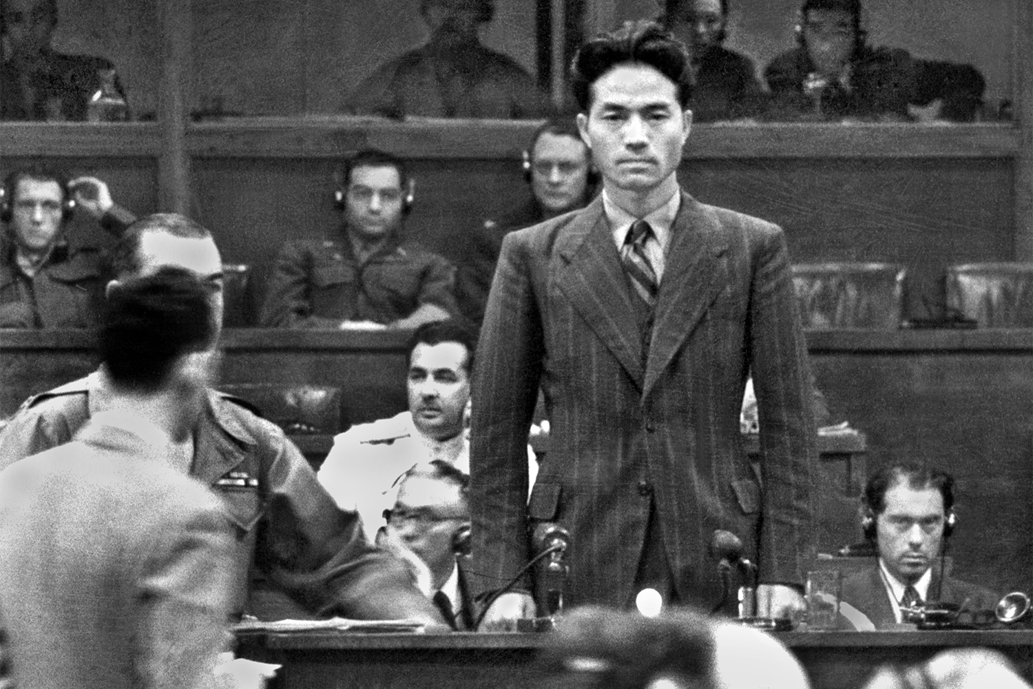 Обвинительное заключение было передано в трибунал 29 апреля 1946 г. Оно охватывало преступления, совершенные в период с 1 января 1928 г. по 2 сентября 1945 г. Как и на Нюрнбергском процессе, обвинения были разделены на три категории: «преступления против мира», «массовые убийства» и «преступления против человечности». Первоначально заключение содержало 55 пунктов, но в окончательном приговоре остались 10. Среди прочего на процессе рассматривались Нанкинская резня (1937) – массовое убийство около 200 000 местных жителей и китайских военных – и «марш смерти» на Филиппинах (1942), в результате которого погибли десятки тысяч военнопленных.На фото: Рюдзо Сэдзима, бывший офицер Императорской армии Японии, сыгравший ключевую роль в планировании многих операций во время войны на Тихом океане и ставший военнопленным в Сибири после службы штабным офицером Квантунской армии в Маньчжурии, дает показания.